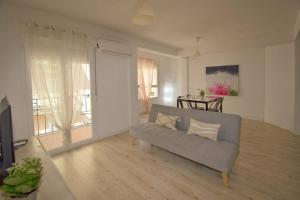 a living room with a couch and a large window at Apartamentos Centro Granada in Granada