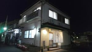ゲストハウス小富士 في أويتا: مبنى عليه علامة في الليل