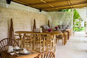 una sala da pranzo con tavoli e sedie in legno di Jellyfish Villas Bingin Beach a Uluwatu