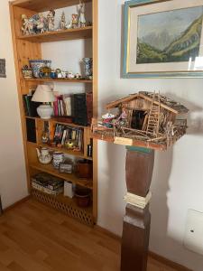 a wooden model of a bird house on a stand next to a book shelf at Bella Stubai in Fulpmes