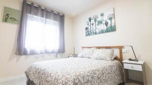 a bedroom with a bed and a window at Apartamento chile playa in Gijón