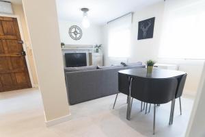 a living room with a table and a couch at Apartamento chile playa in Gijón