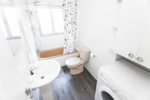 a white bathroom with a sink and a toilet at Apartamento chile playa in Gijón +9 photos