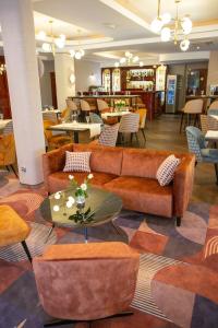 a lobby with couches and tables and chairs at Hotel Styl 70 in Pszczyna