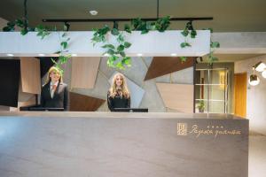 two women sitting at a counter in a lobby at Hotel Rajska dolina Jahorina in Jahorina