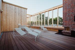 Drei Stühle und ein Tisch auf einer Holzterrasse in der Unterkunft SeeLoge Eutin in Eutin