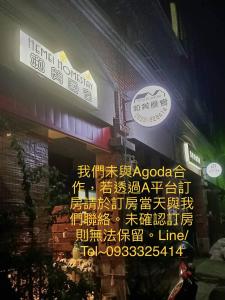 un gruppo di cartelli sul lato di un edificio di HeMei Homestay a Ho-mei