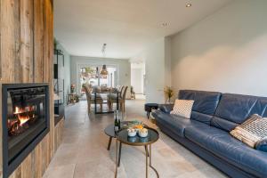 ein Wohnzimmer mit Couch und Kamin in der Unterkunft Maison Odett - fully renovated house for 10 people in Nieuwpoort
