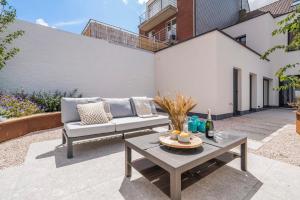 a patio with a couch and a table at Maison Odett - fully renovated house for 10 people in Nieuwpoort
