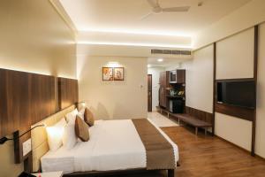 a hotel room with a bed and a flat screen tv at Spree Hotel Aurangabad in Aurangabad