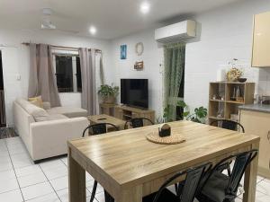 cocina y sala de estar con mesa y sofá en Withanee, en Picnic Bay