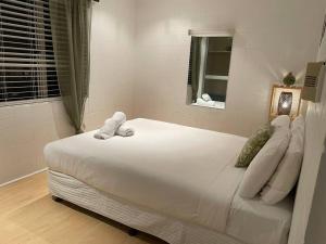 Schlafzimmer mit einem großen weißen Bett und einem Fenster in der Unterkunft Withanee in Picnic Bay