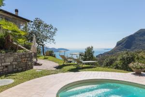 una piscina en un patio trasero con una mesa y un banco en Malga Mary, en Tignale