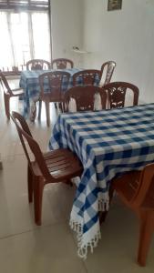 un comedor con una mesa y sillas de color azul y blanco a cuadros en Fair View Bungalow, en Kataragama