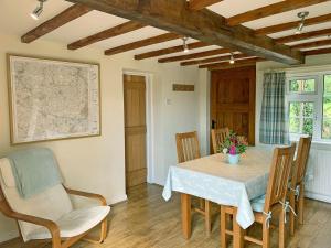 Hollywell Cottages في Clifton: غرفة طعام مع طاولة وكراسي