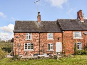 an old red brick house with white windows at Hollywell Cottages in Clifton