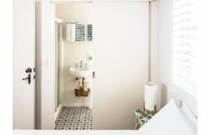 a small bathroom with a sink and a toilet at WategosRent in Byron Bay