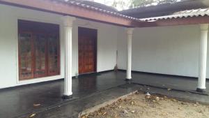 een leeg huis met twee deuren en zuilen bij Fair View Bungalow in Kataragama