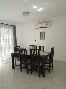 a dining room with a table and four chairs at Tricia's PLACE - One family at a time in Accra