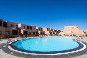 a swimming pool in the middle of a apartment complex at Home2Book Casa La Pepita 2 in Caleta De Fuste