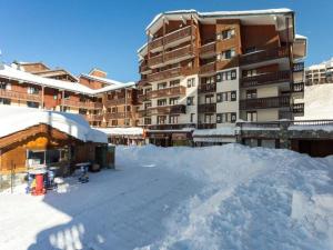 a snow covered parking lot in front of a large building at Appartement 123 (RDP) in Tignes