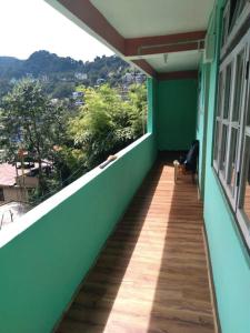 a balcony of a green building with a view of a city at BOJO house in Gangtok