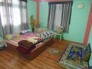a bedroom with a bed and a chair in it at BOJO house in Gangtok
