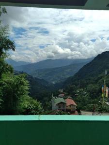 a view of a valley with a house and mountains at BOJO house in Gangtok