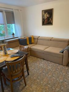 ein Wohnzimmer mit einem Sofa und einem Tisch in der Unterkunft Lorin Prestige Apartament in Elblag