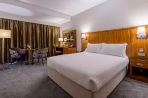 a hotel room with a large bed and a desk at Glashaus Hotel in Tallaght