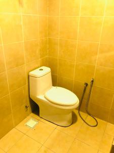 a bathroom with a toilet with a hose at 3 room apartment with garden view in Banting