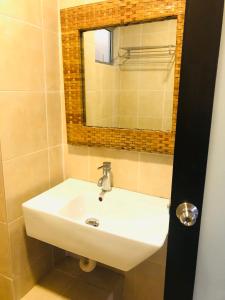 a bathroom with a white sink and a mirror at 3 room apartment with garden view in Banting