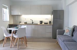 a kitchen and living room with a table and a couch at Central Cozy Residences in Sitia