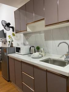 a kitchen with a sink and a microwave at White Oak Residences - Baguio Megatower 3 in Baguio