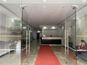 a red carpet in a glass hallway with a woman sitting at a table at White Oak Residences - Baguio Megatower 3 in Baguio
