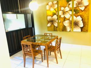 a dining room with a glass table and two chairs at 3 room apartment with garden view in Banting