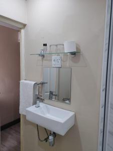 a bathroom with a white sink and a mirror at Prime Hotel in Durban