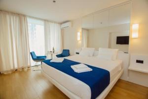 una camera con un grande letto e due sedie blu di Superior Apartments Orbi City Sea View a Batumi
