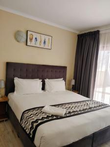 a bedroom with a large bed with a keyboard on it at Prime Hotel in Durban