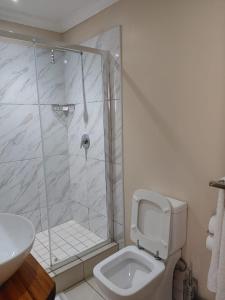 uma casa de banho com um chuveiro, um WC e um lavatório. em Prime Hotel em Durban