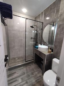 ein Bad mit einer Dusche, einem Waschbecken und einem WC in der Unterkunft Zest hotel & spa in Oral