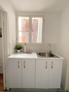 a white kitchen with a sink and a window at La Residencia de Espiritu Santo in Madrid