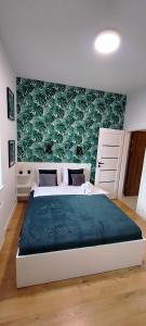 sypialnia z dużym łóżkiem i zieloną ścianą w obiekcie Nowoczesny apartament z widokiem na park w mieście Rzeszów