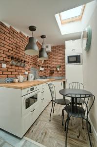 a kitchen with a table and a brick wall at Urban Nest Apartments Bon 5 in Krakow