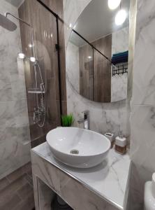 a white bathroom with a sink and a shower at Zest hotel & spa in Uralsk