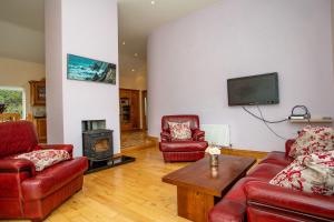 a living room with two red couches and a tv at Church Island View Holiday Home in Waterville