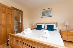 a bedroom with a large white bed with blue pillows at Church Island View Holiday Home in Waterville