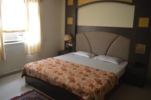 a bedroom with a large bed and a window at Hotel City Palace in Brahmapur
