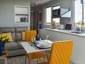 a kitchen and living room with a table and a couch at Uk39216 - Swn Y Mor in Holyhead