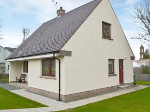 a white house with a gambrel roof at Cluaran Cottage in Tain